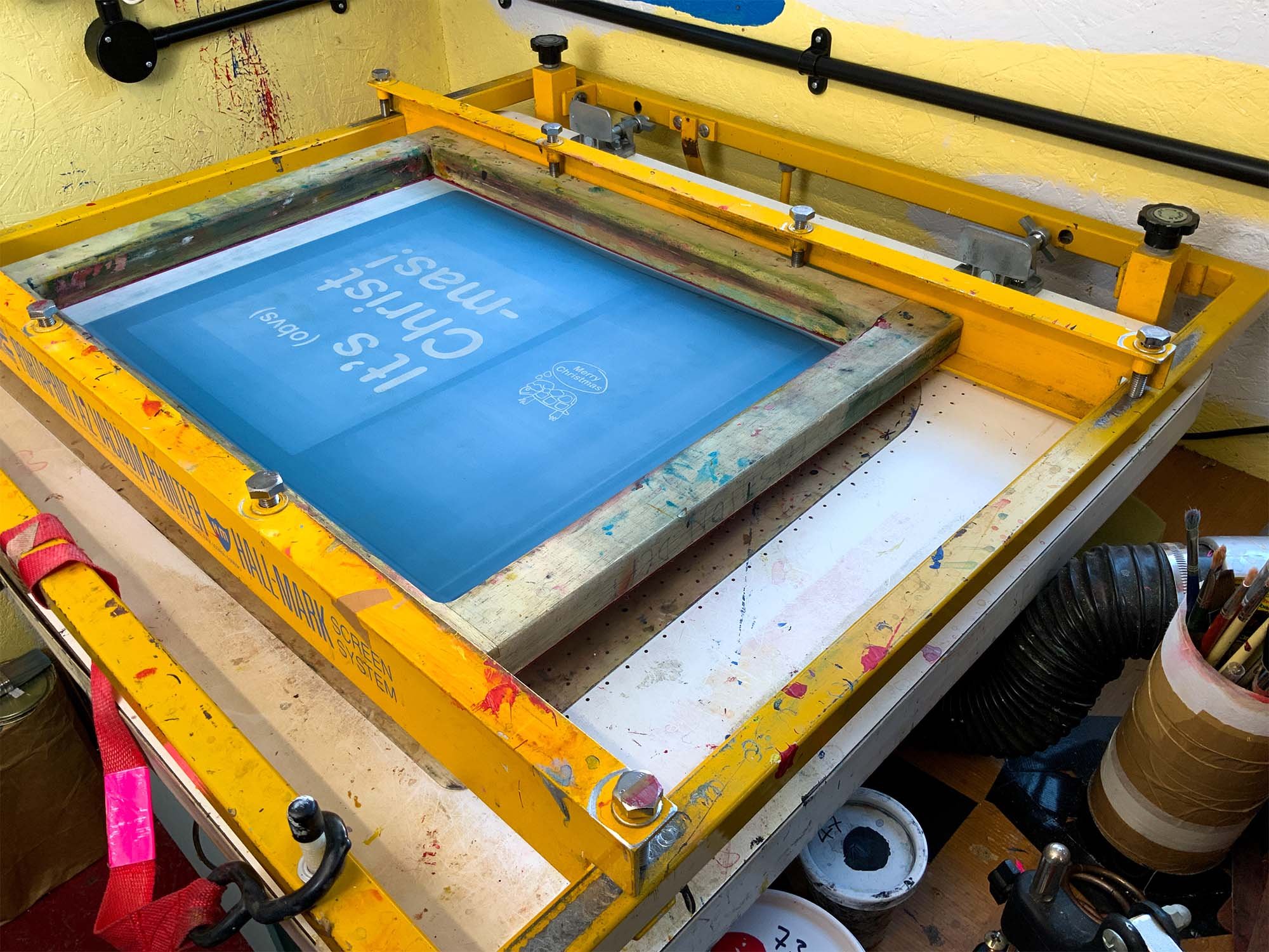 photo of screen print vacuum table with screen used to print 'Cracker' greetings card
