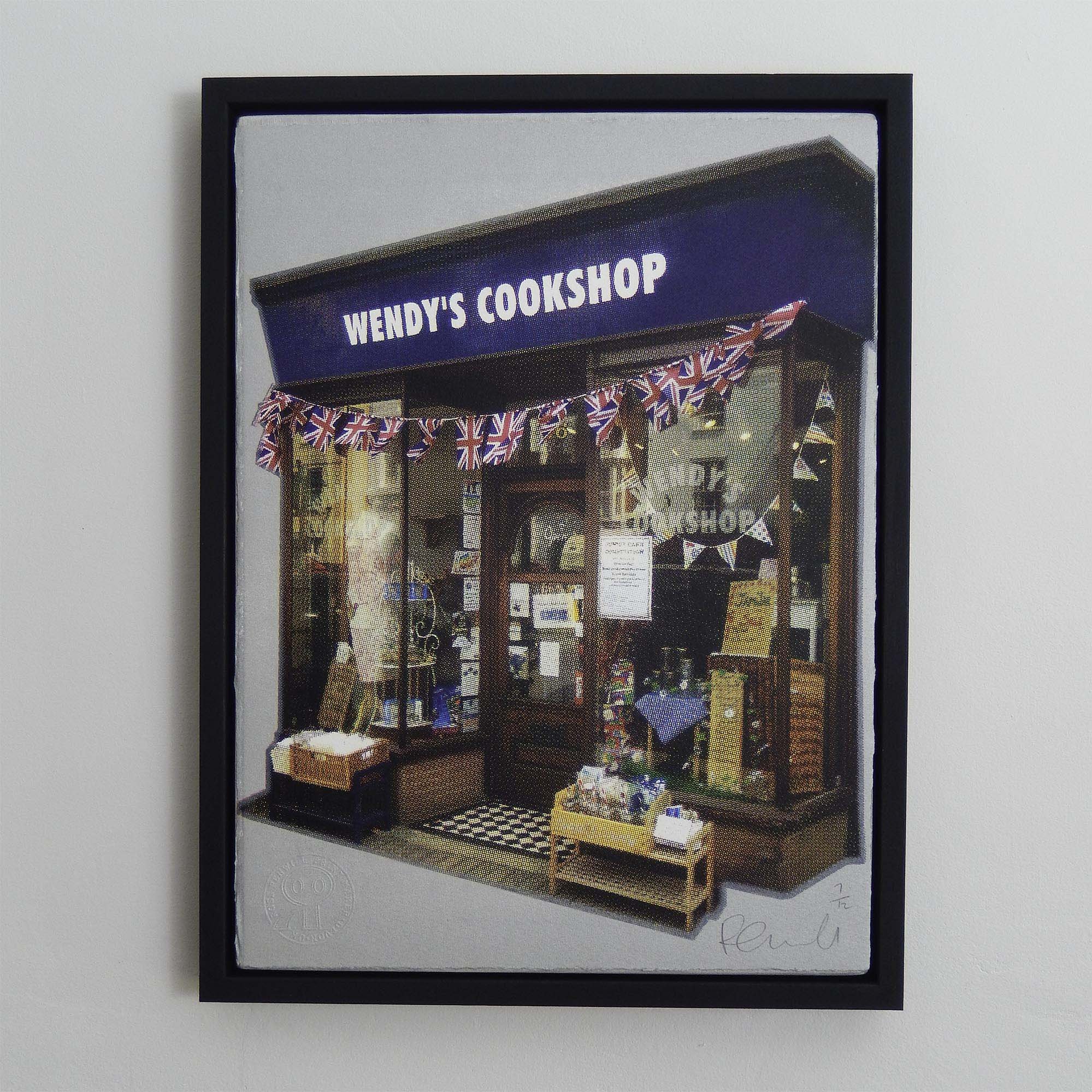 Framed picture of "Wendy's Cookshop" storefront with British flag bunting.
