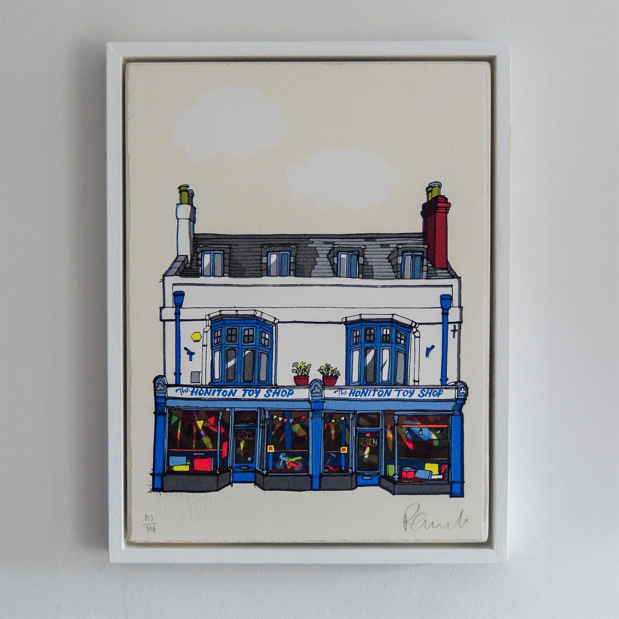 Illustration of a toy shop with blue and white facade, labeled "The Honiton Toy Shop," featuring colorful toy displays in the windows.