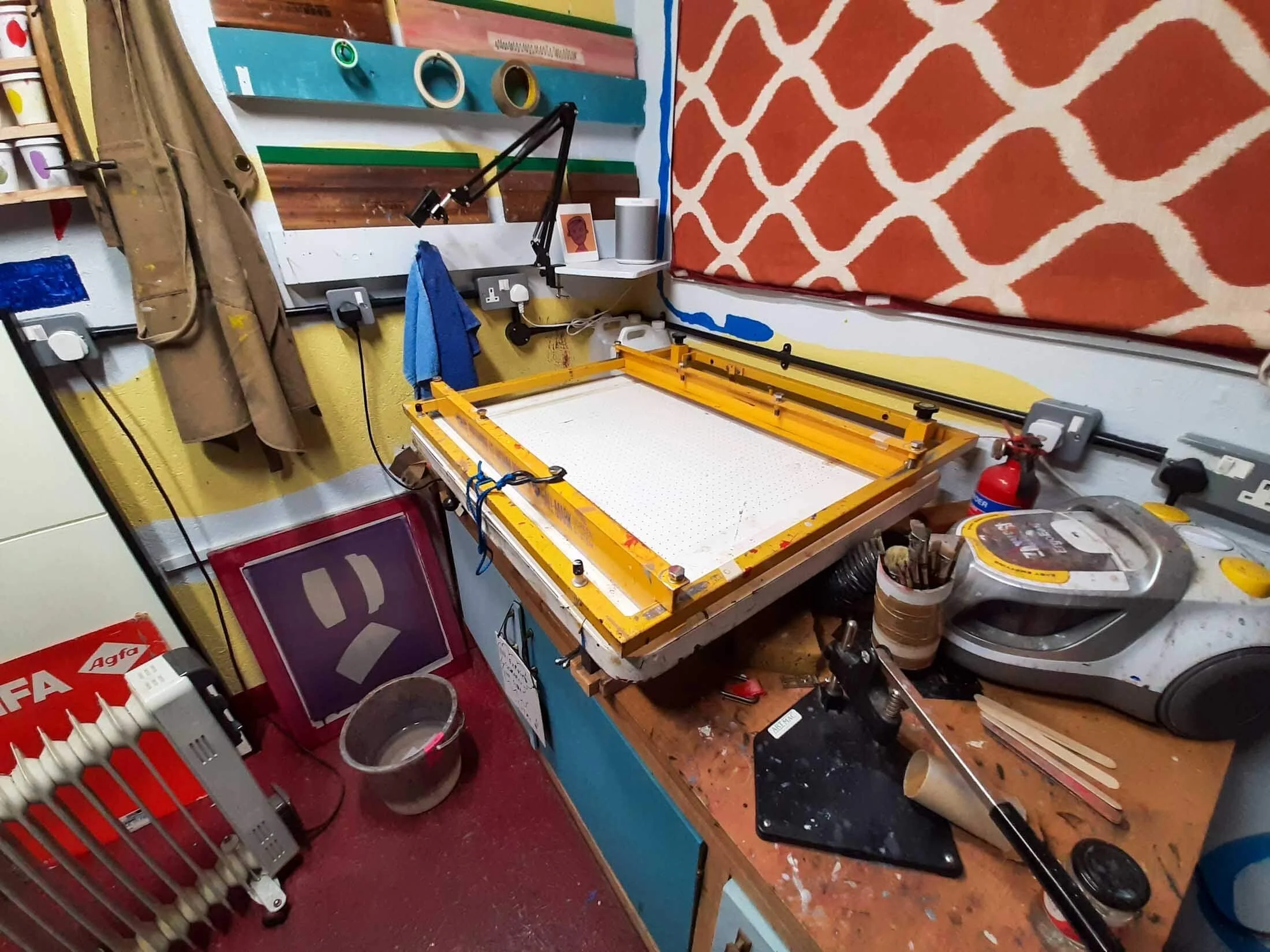 Multiple wall sockets installed at different heights around a vacuum table in a screen printing studio.