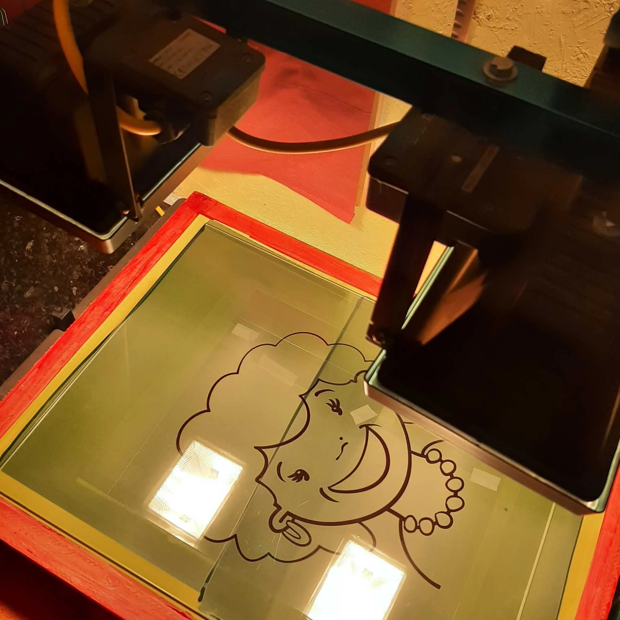 Aerial view of silkscreen screen being exposed below lamps