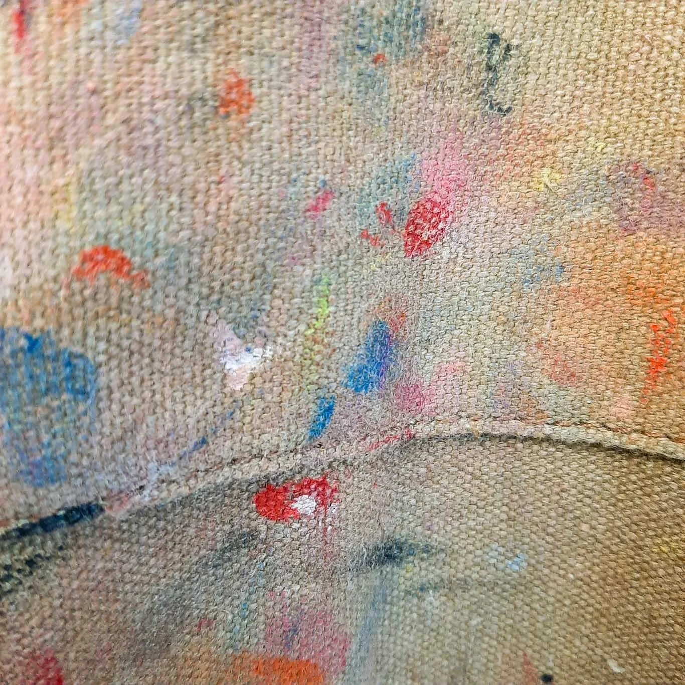 Printmaker’s apron covered in colourful ink splodges, showing the realities of studio work.