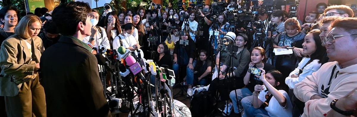 Celebrity presenter talking to a group of media