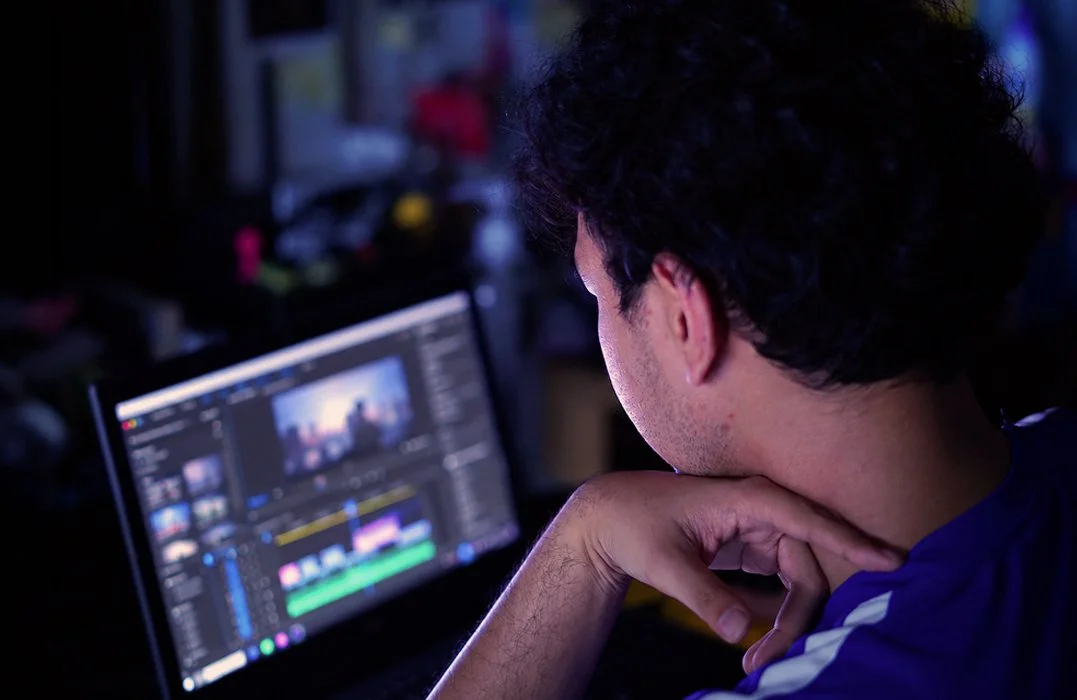 Creative content header image with a man looking at video editing software