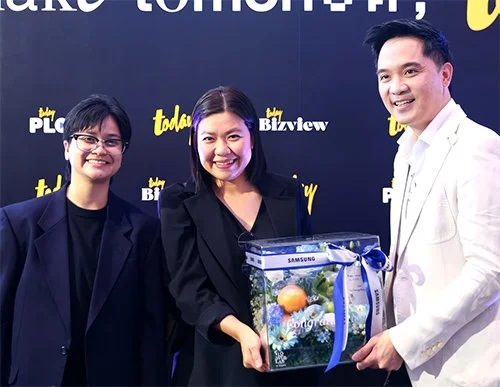Member of ABM Media team giving a gift to media at an anniversary event