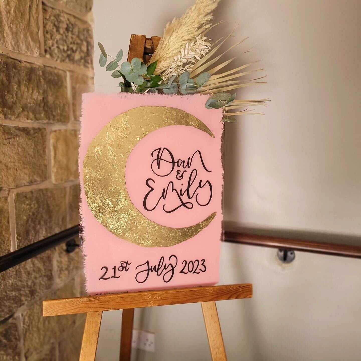 🌜Let's flashback to this wonder of a welcome sign 

- a gold leaf moon, black calligraphy on aceylic with a pink paint background 🥰 - such a beautiful bold greeting for guests! 

@emily.kate.x
@cameraman_dan

Dried foliage styling by @emilykwedding