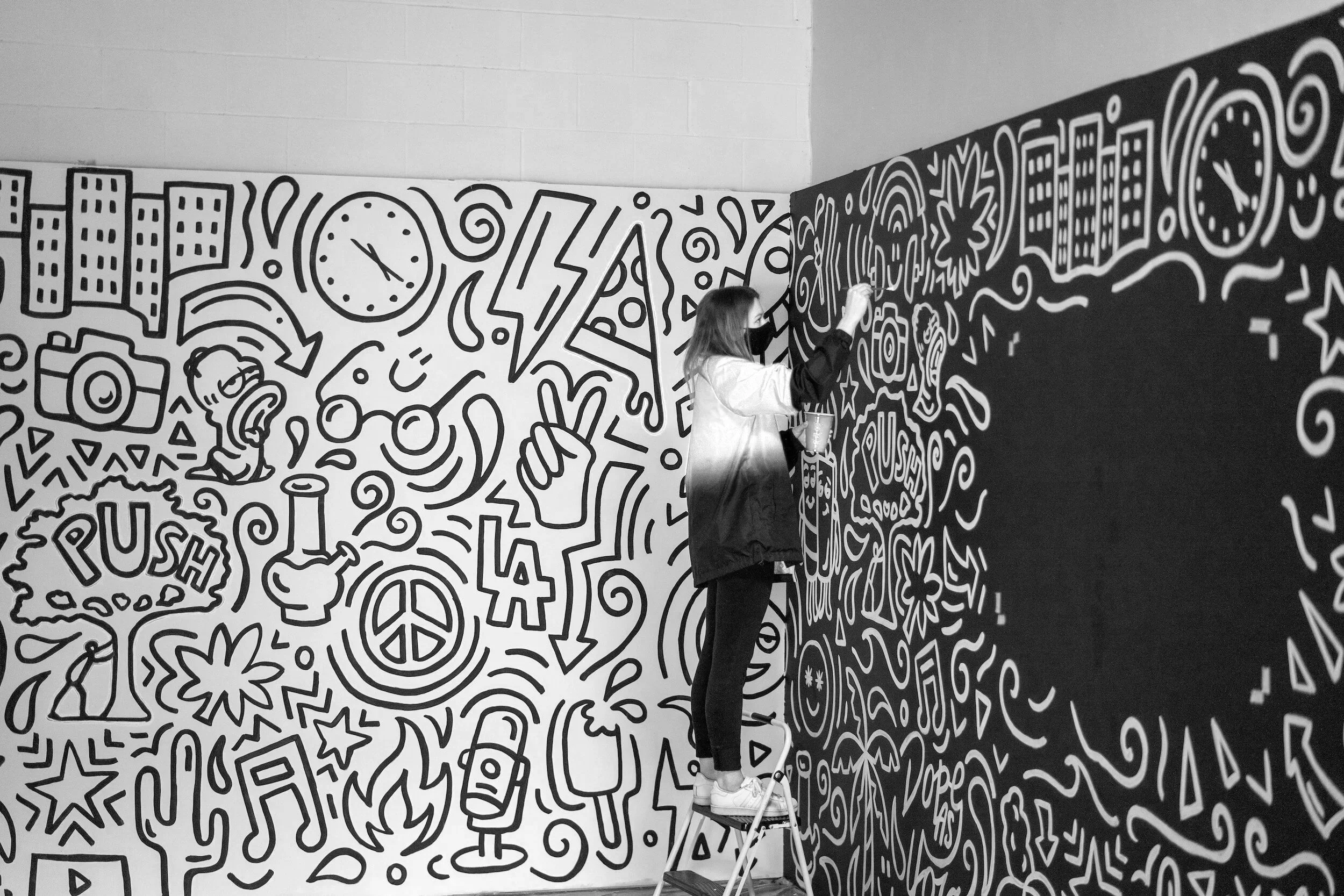 Kuvituskuva taiteilijasta maalaamassa seinää.