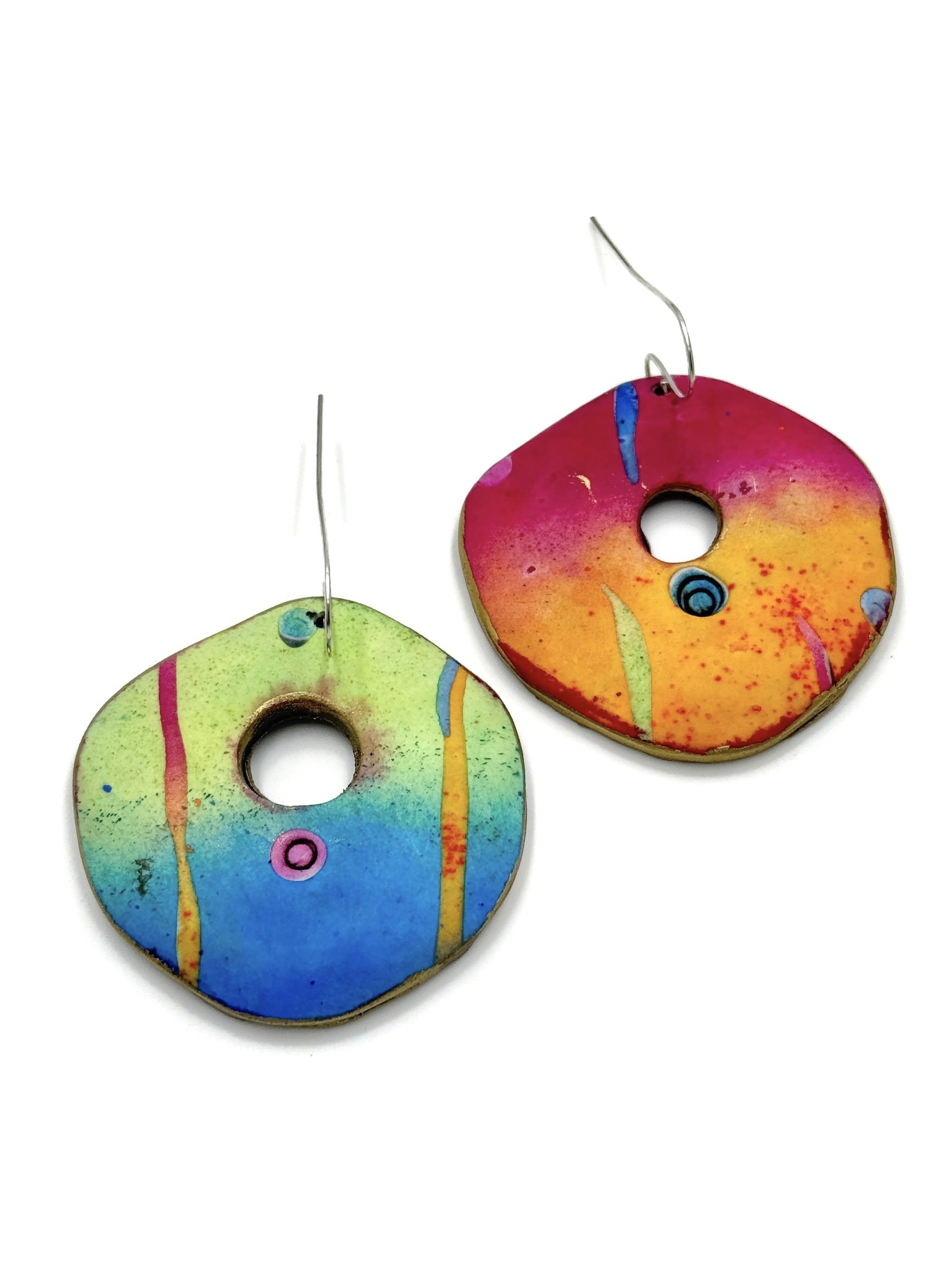 Colorful mismatched polymer clay earrings in sculptural organic shapes, featuring gradient hues of fuchsia, orange, green, and blue on white background