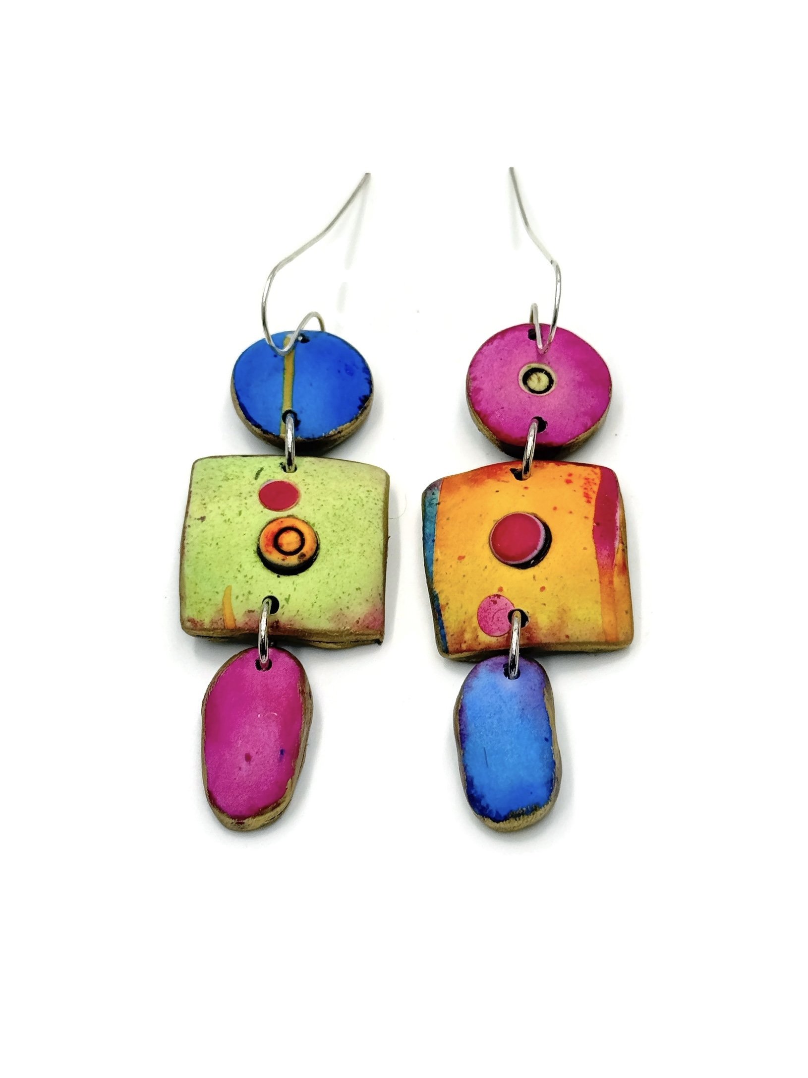 Mismatched handmade polymer clay earrings in vibrant pink, green, blue, and orange with sculptural 3-piece design