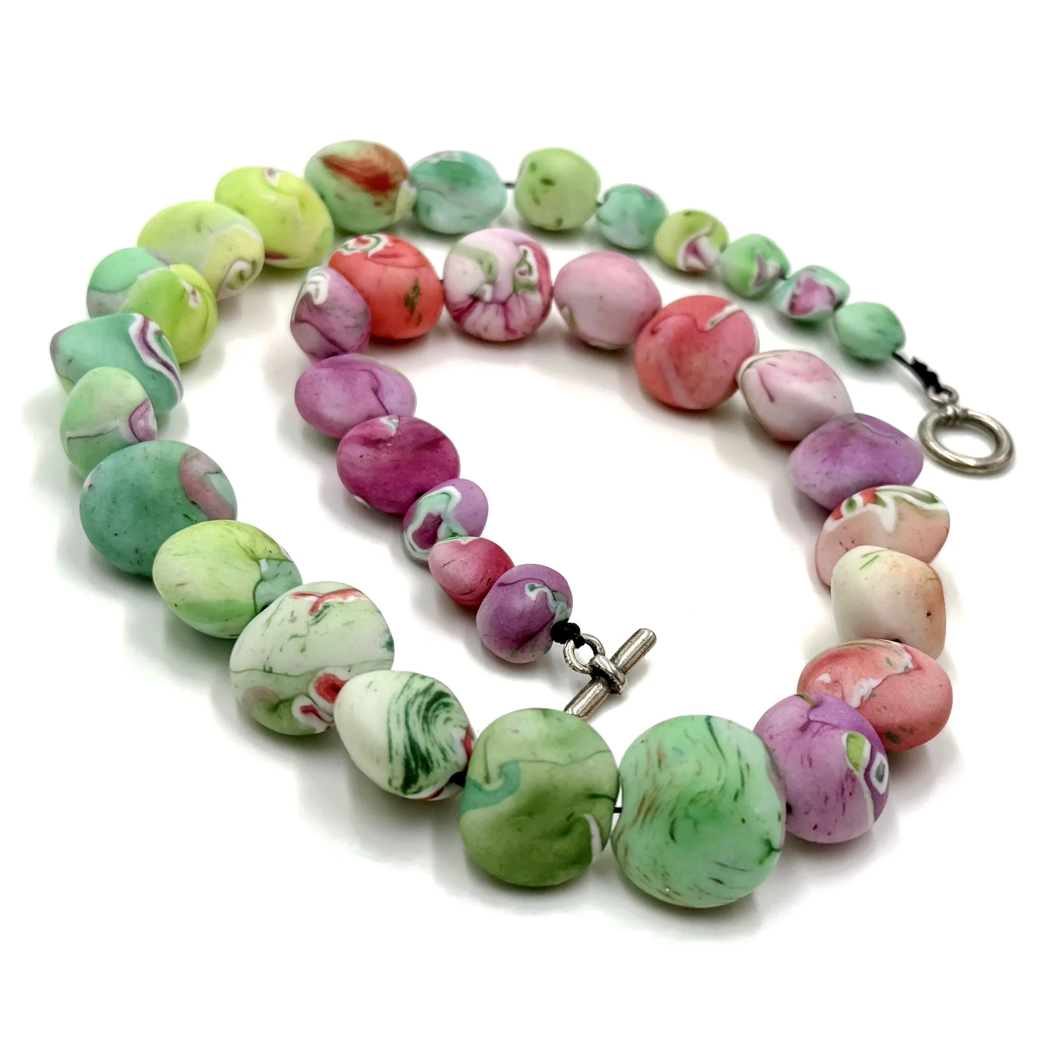 Handmade colorful organic bead necklace in green, pink and lilac tones with rounded pebble shapes