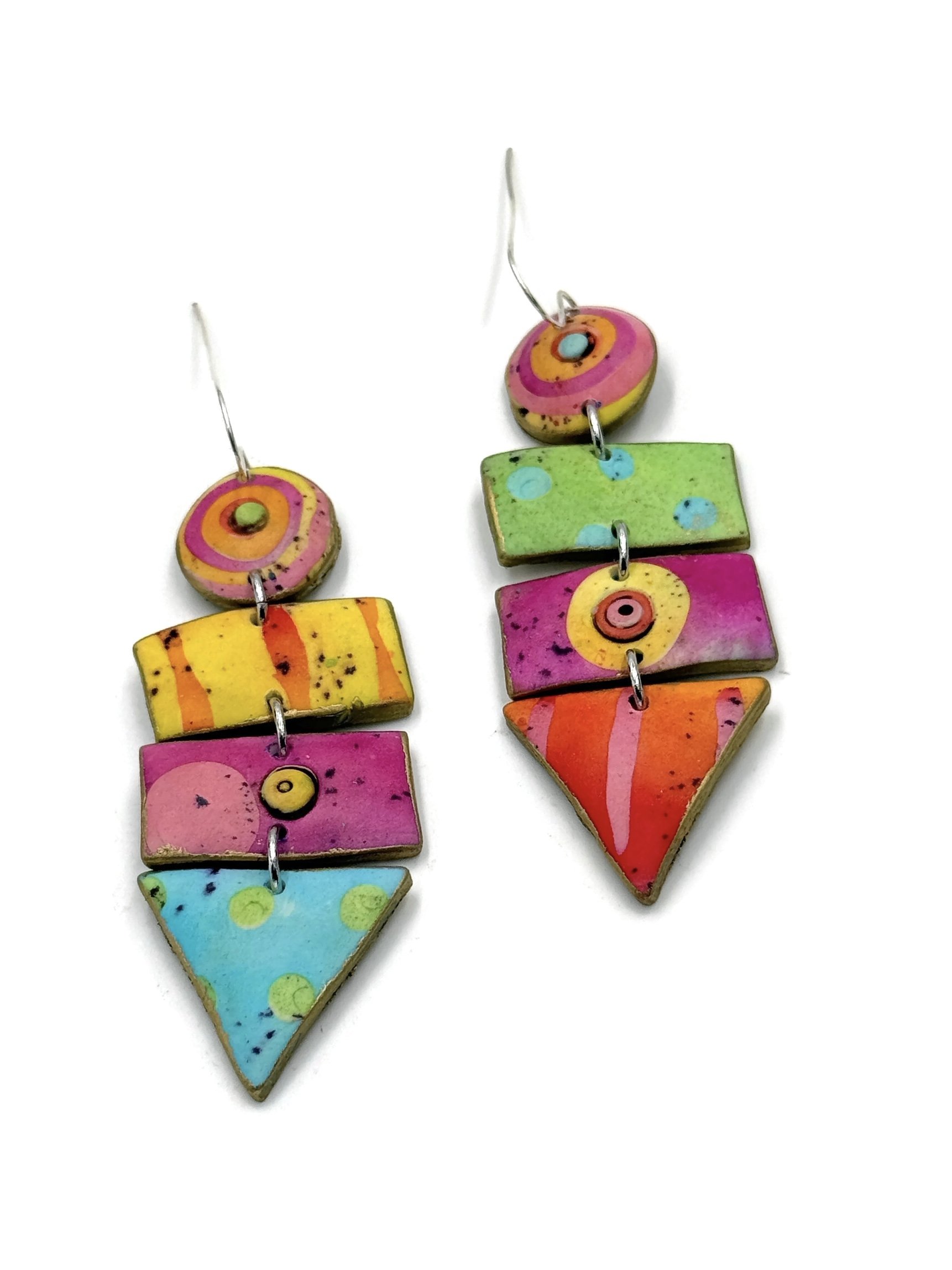 Handmade geometric statement earrings with circles, rectangles, and triangle shapes in pink, turquoise, lime green, yellow, and orange tones with graphic patterns.