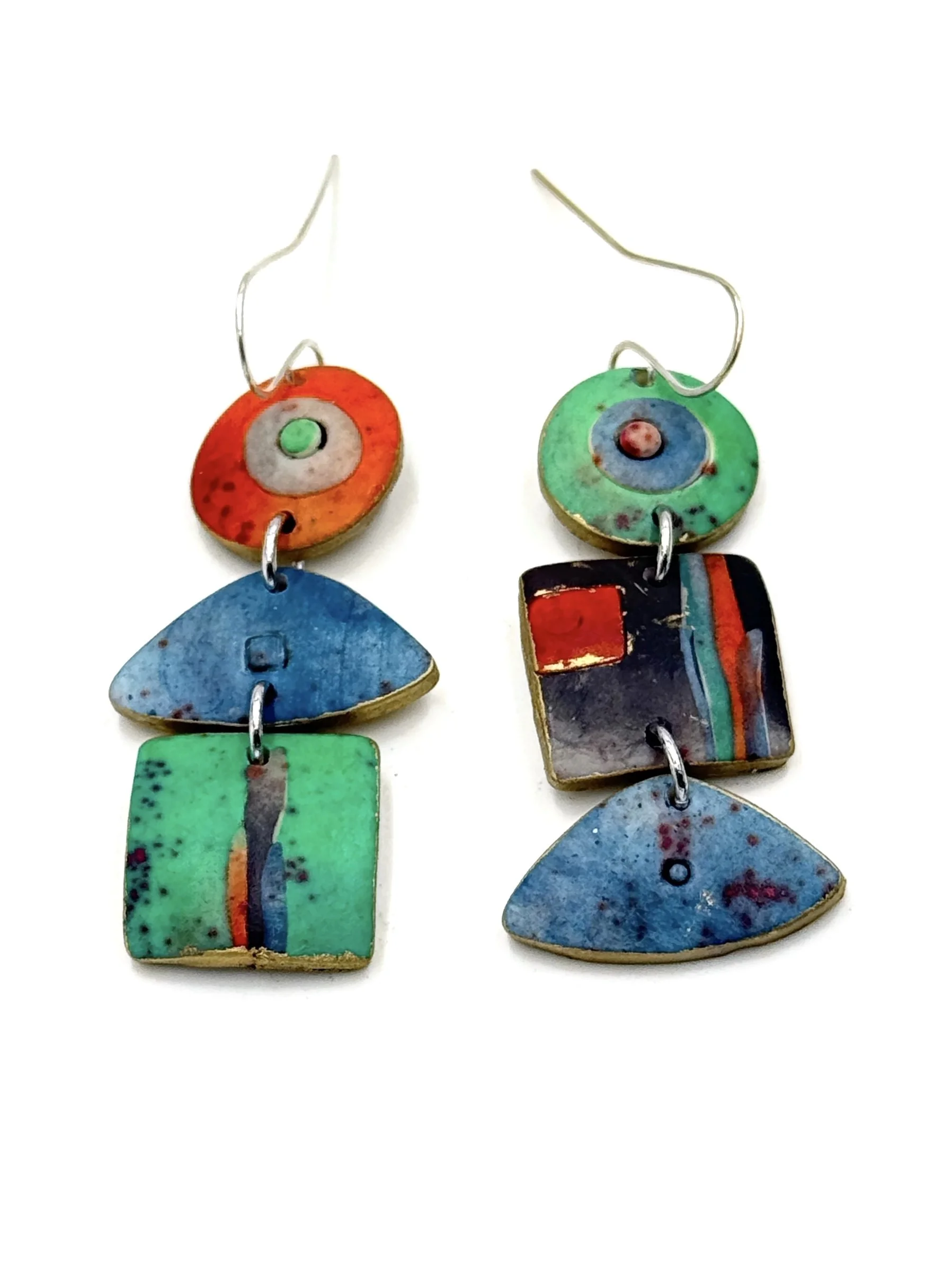 Handmade asymmetrical geometric drop earrings in turquoise, blue, green, and orange with painterly textures and silver-plated ear wires.