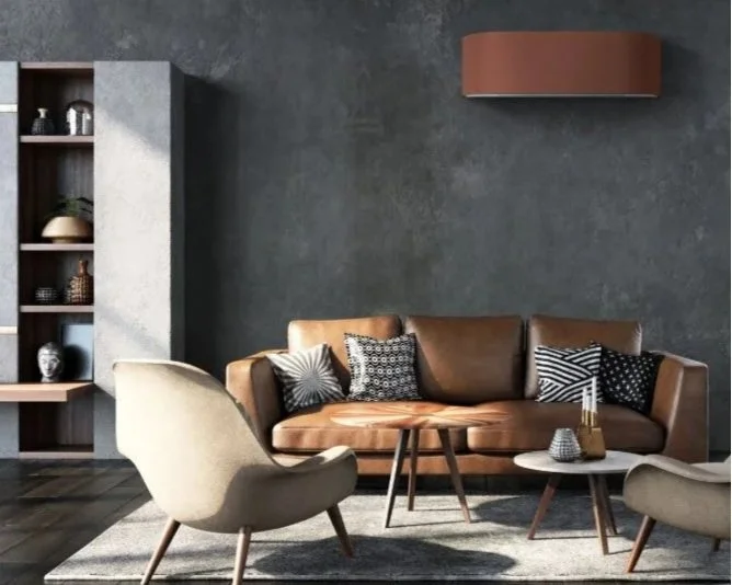 Innendørsmøbler i stue med brun skinnsofa, to beige lenestoler og to små sidebord foran en mørk grå vegg.