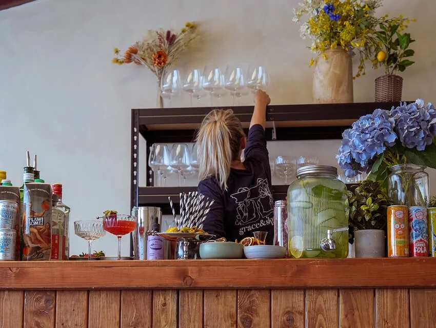 A woman holding an iced matcha in her hand with her back to the camera.