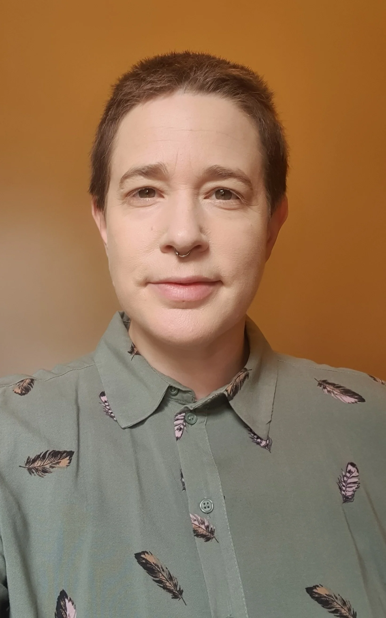white queer therapist wearing shirt with feathers