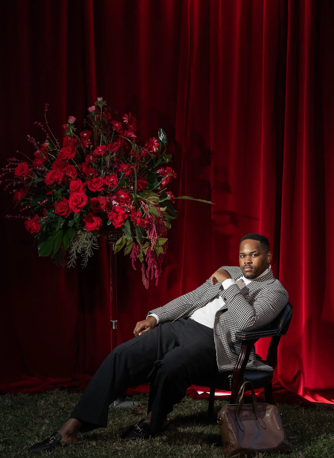 Daniel Davis in herringbone suit jacket with red velvet backdrop