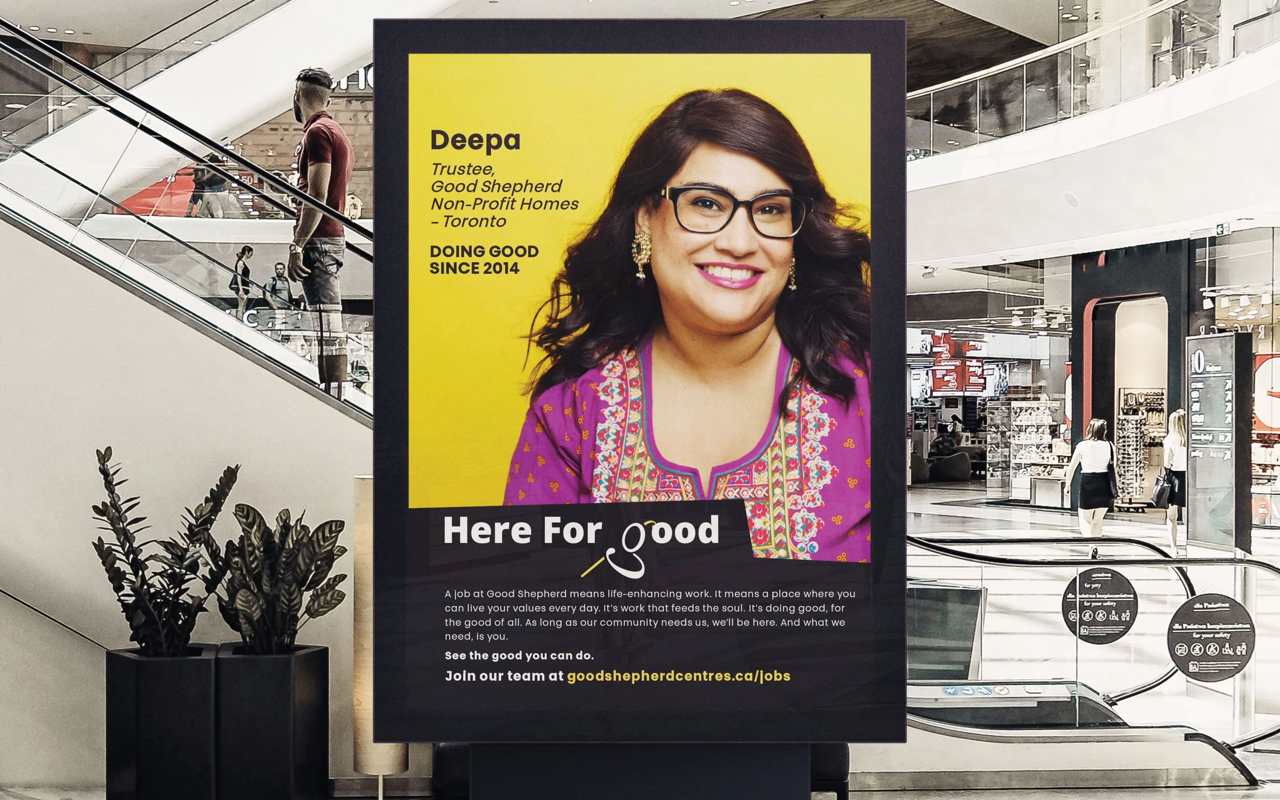 Mall corridor with large advertisement featuring a woman named Deepa, highlighting her role as a trustee for Good Shepherd Non-Profit Homes in Toronto.