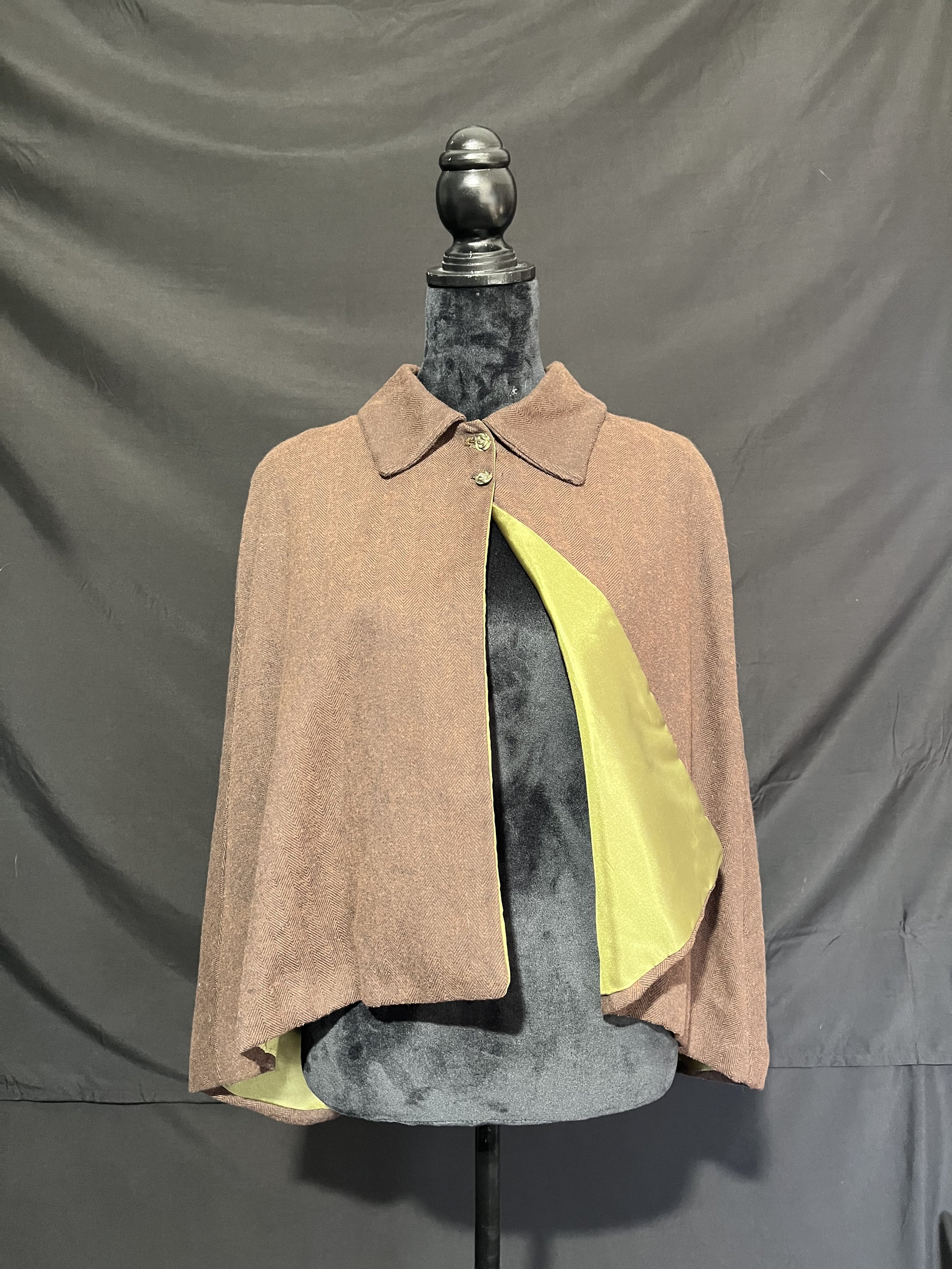 Capelet with all enclosed seams and interior satin lining. Hand sewn buttonholes on center front