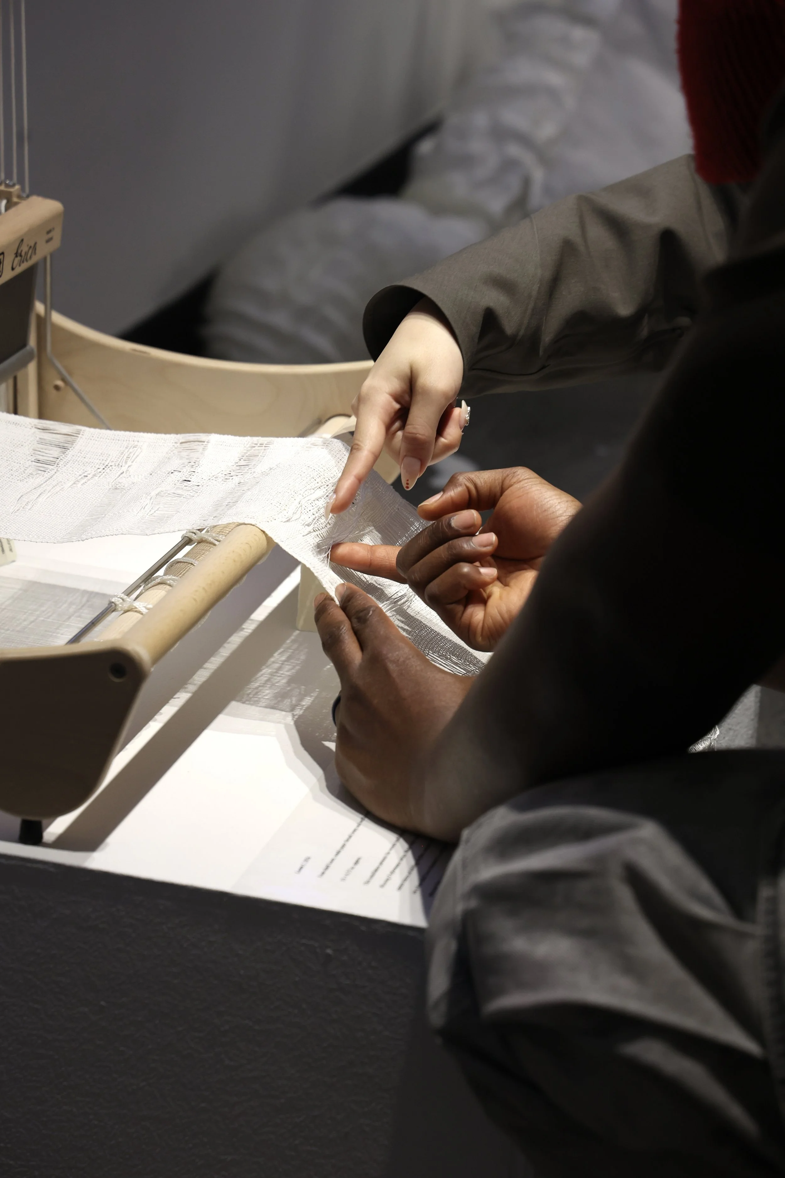 Visitors examined the woven cloth on the loom during the opening reception, as the exhibition space became a site of conversation, looking, and shared attention. Photograph by Aritra Das, 2026.