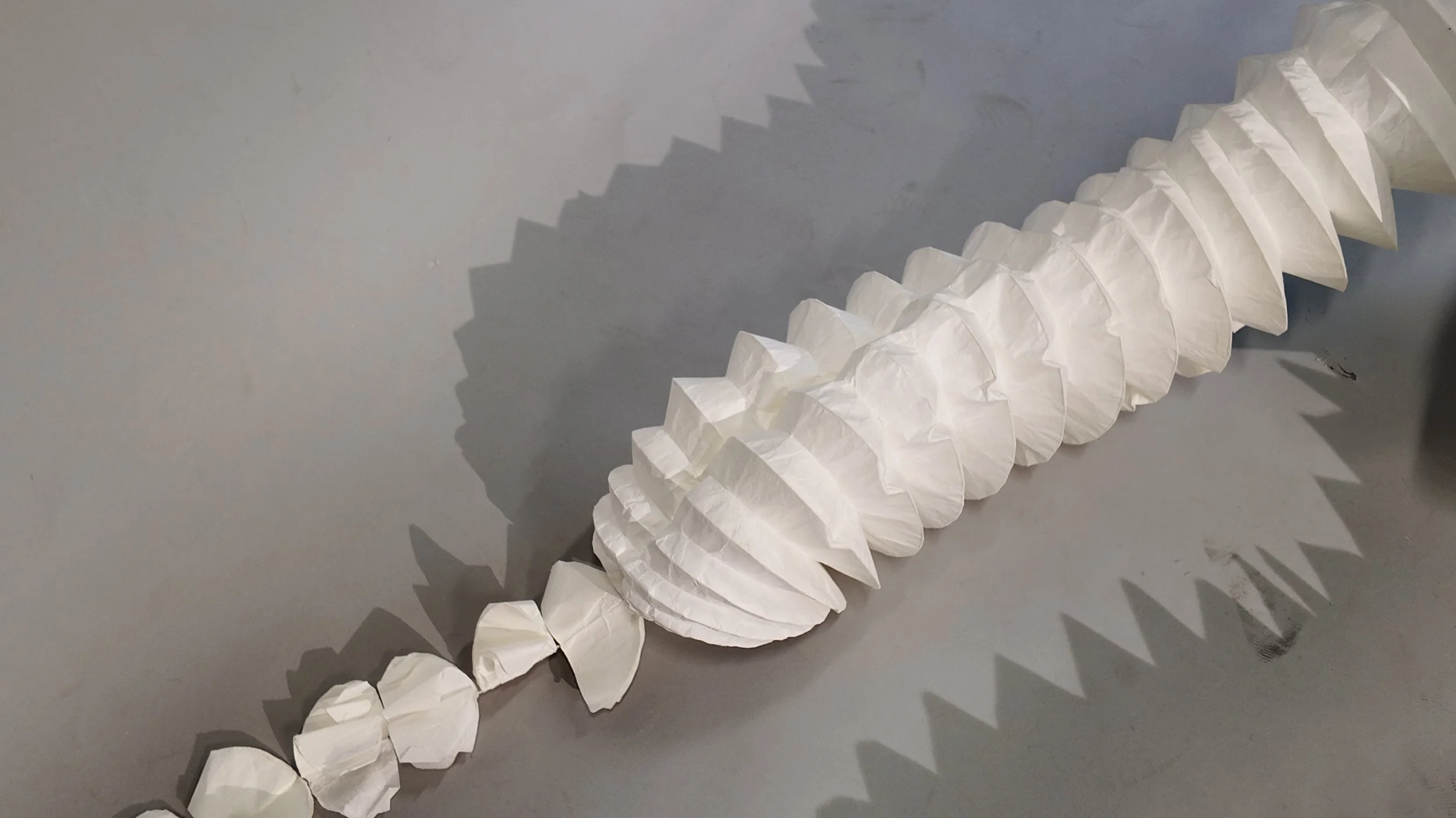 Detailed view of the opened tentacle structure in the final squid-yokai costume, showing the circular-sleeve construction in white washi paper that allows the form to expand, contract, and fold for transport. Adapted from Tomoko Nakamichi’s Pattern M
