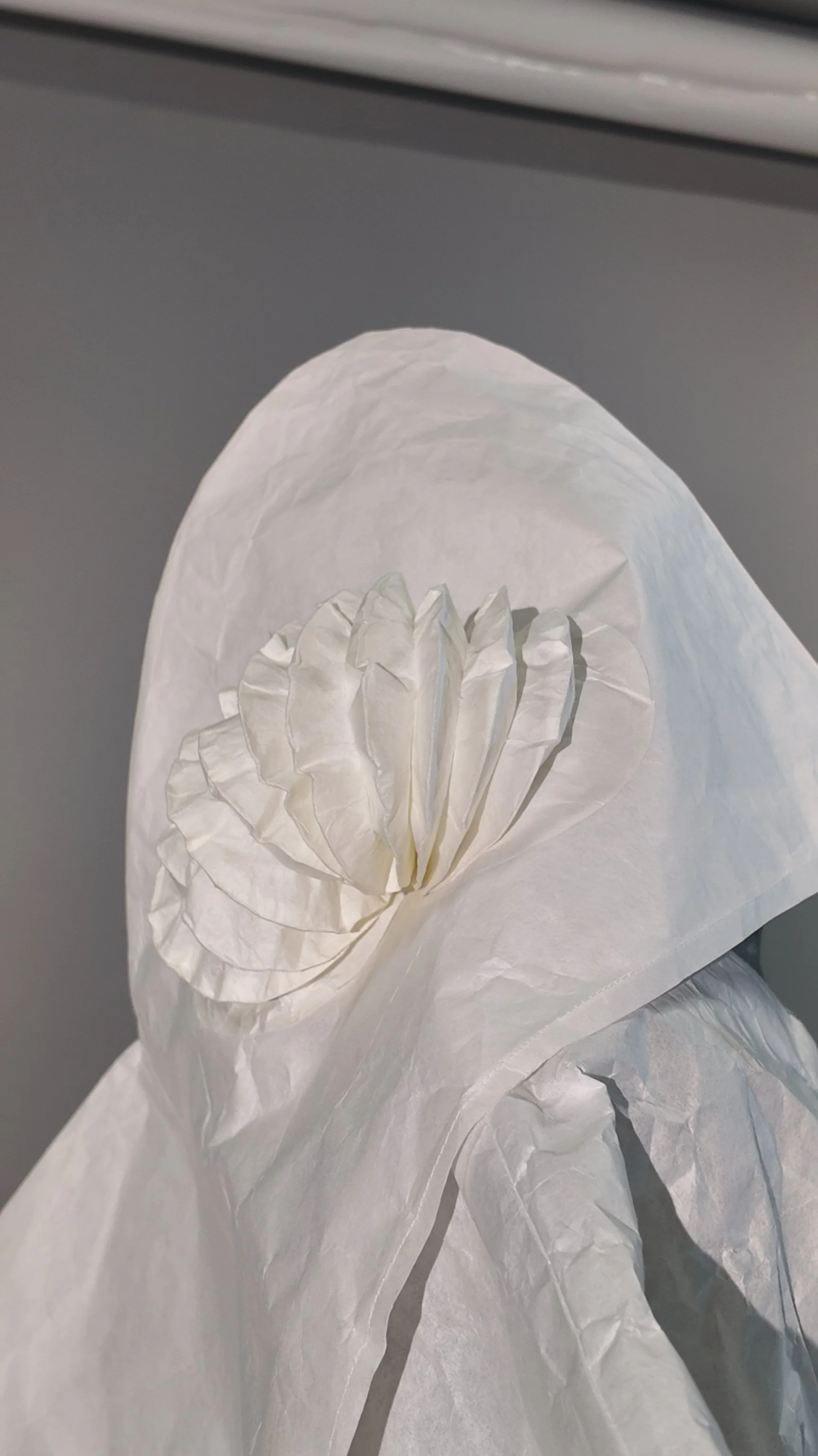 Detail of the hood and eye-like paper form in the final white washi paper squid-yokai costume, showing the repeated circular folded structure that unifies the head and tentacle elements. Adapted from Tomoko Nakamichi’s Pattern Magic 2 (2011, p. 49). 