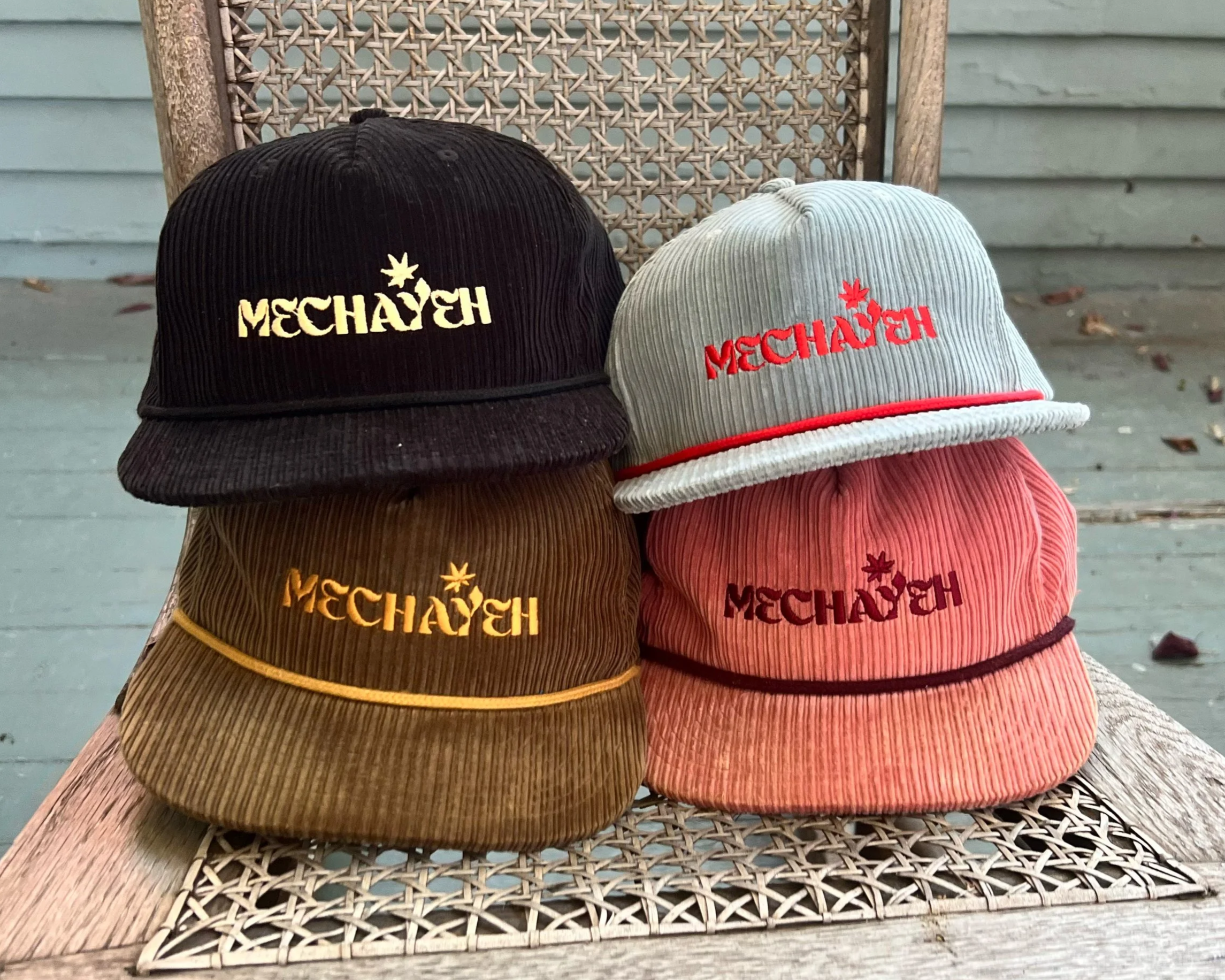 Four Mechayeh corduroy caps on a wicker chair