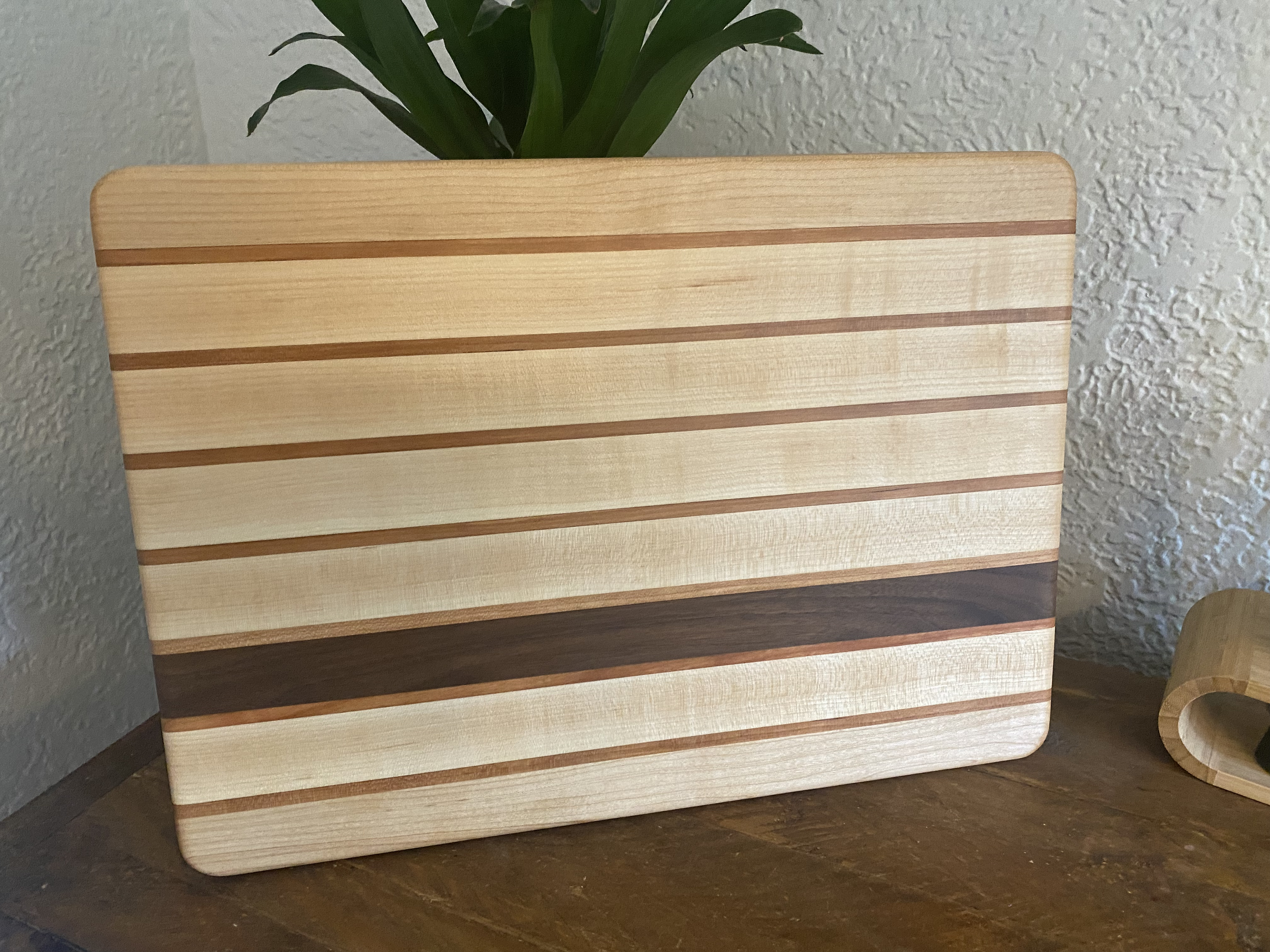 Cherry Stripe hardwood cutting board made from maple, cherry, and walnut, featuring horizontal stripe design and a smooth surface for chopping, slicing, and kitchen prep.