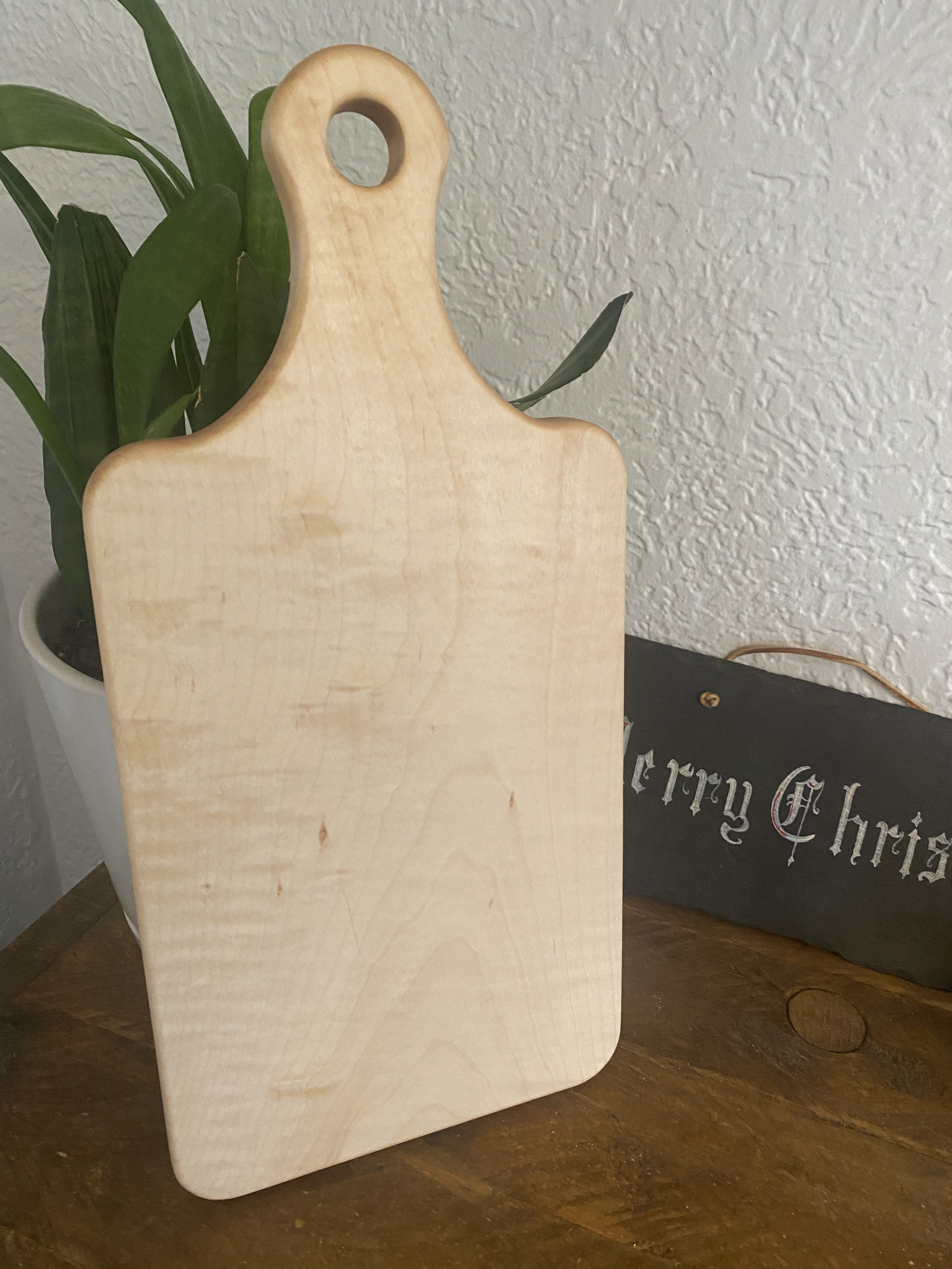 Maple cutting board with handle and hanging hole, made from solid hardwood maple, featuring a smooth surface for chopping, slicing, and serving.