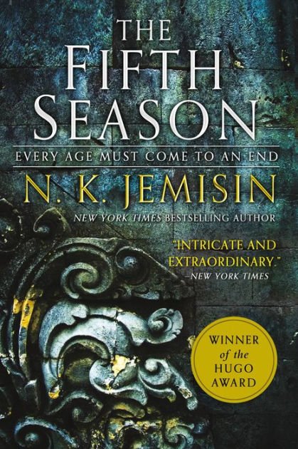 Cover of the book titled 'The Fifth Season' by N.K. Jemisin. The background features a textured dark greenish-blue stone wall with a decorative stone carving. A yellow sticker indicates it is the winner of the Hugo Award. The author's name appears in large yellow letters, and there is a quote describing the book as 'intricate and extraordinary.'
