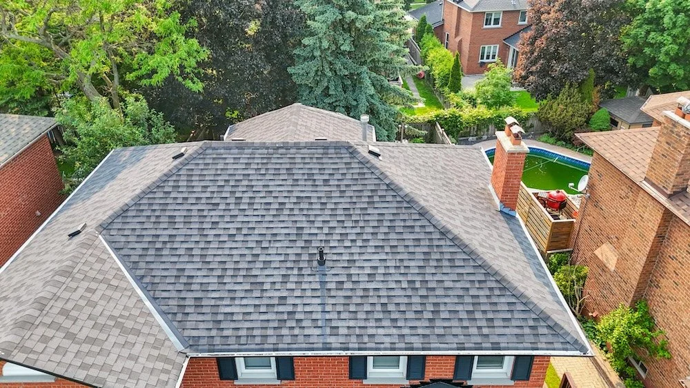 All‑black shingle roof replacement in Whitby, Ontario with black aluminum fascia and eavestroughs