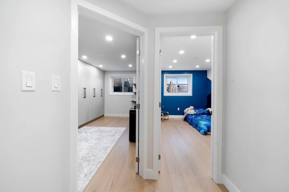 Finished basement hallway with clean white walls and wood flooring in Oshawa renovation project