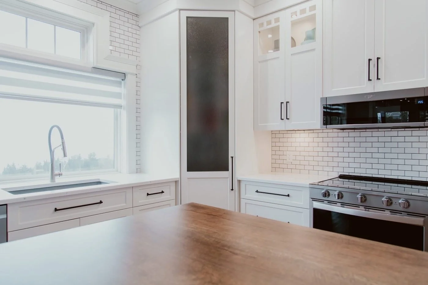 Modern kitchen renovation featuring custom pantry storage with deep pull-out drawers and floor-to-ceiling cabinetry.