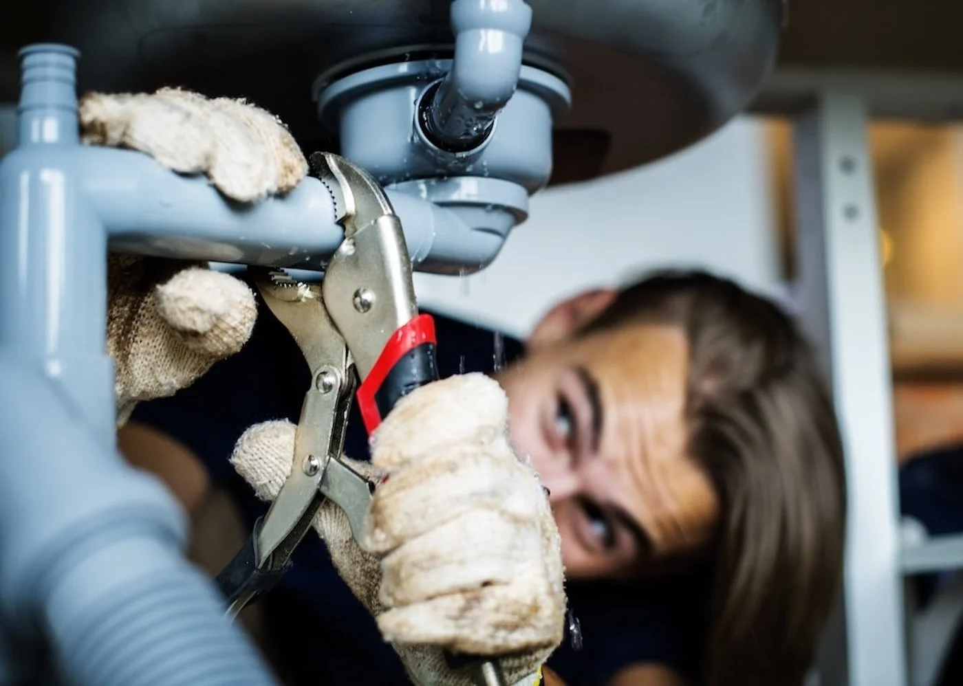 Man fixing basement kitchen sink