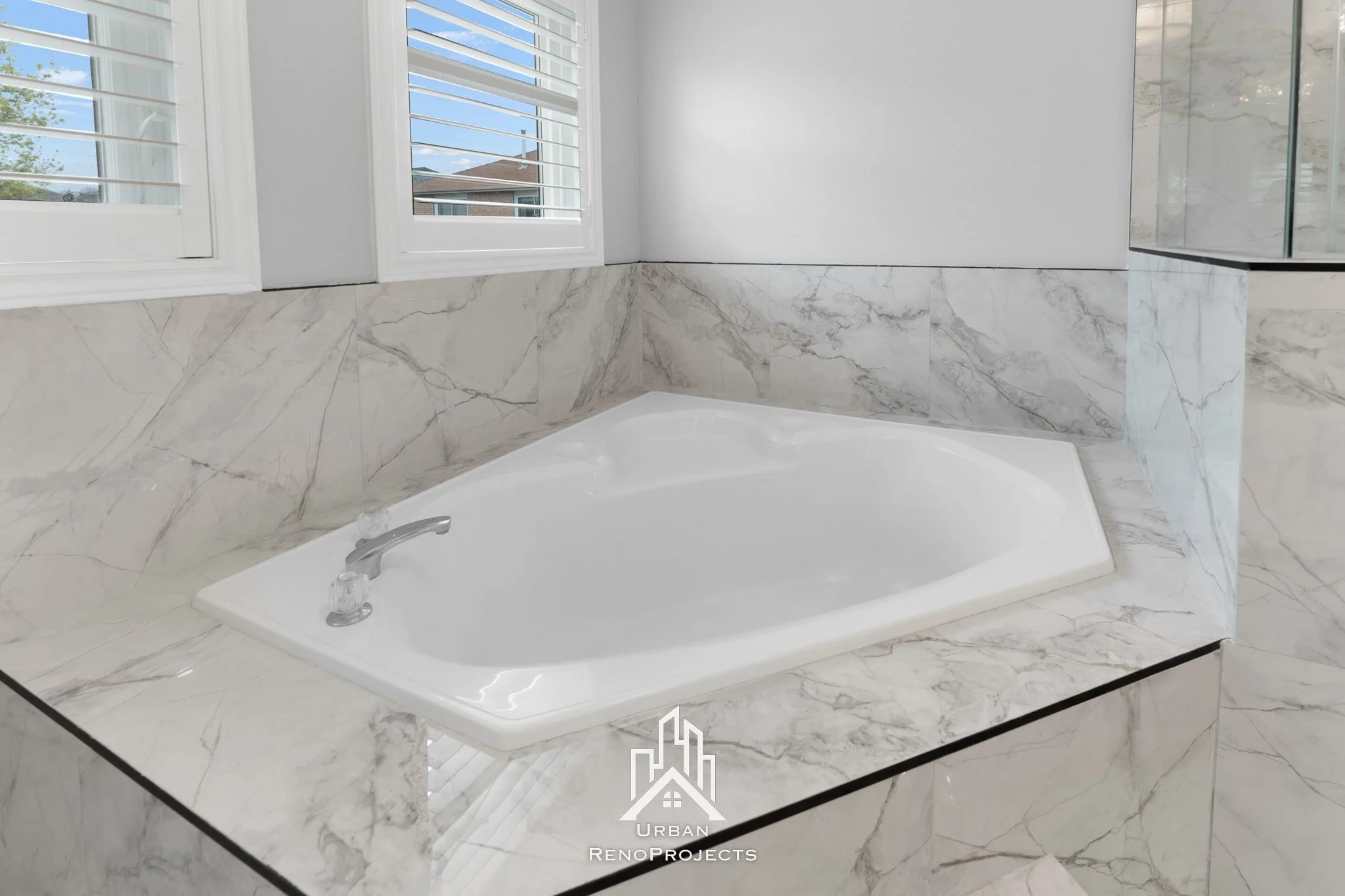 Luxurious master bathroom reveal in Pickering, featuring a relaxing jacuzzi tub alongside a walk-in shower with a matching bench, half-tiled walls, an LED niche, and modern matte black fixtures.