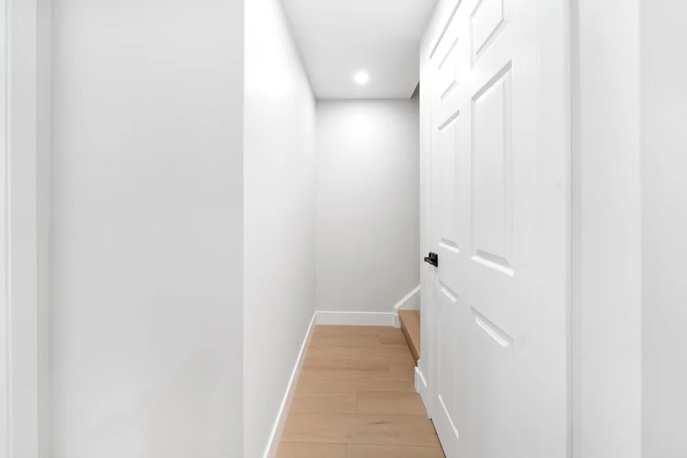 Modern basement hallway in Oshawa backsplit renovation with light oak flooring and recessed lighting
