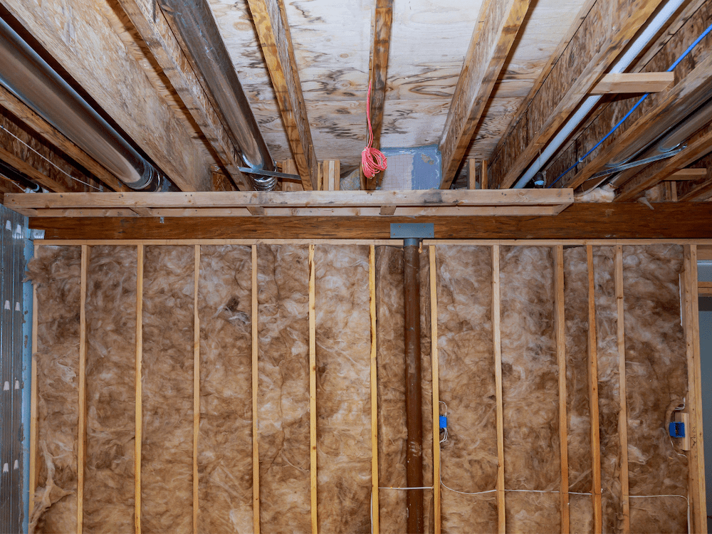 Interior wall insulation of basement with fiberglass cold barrier and insulation material