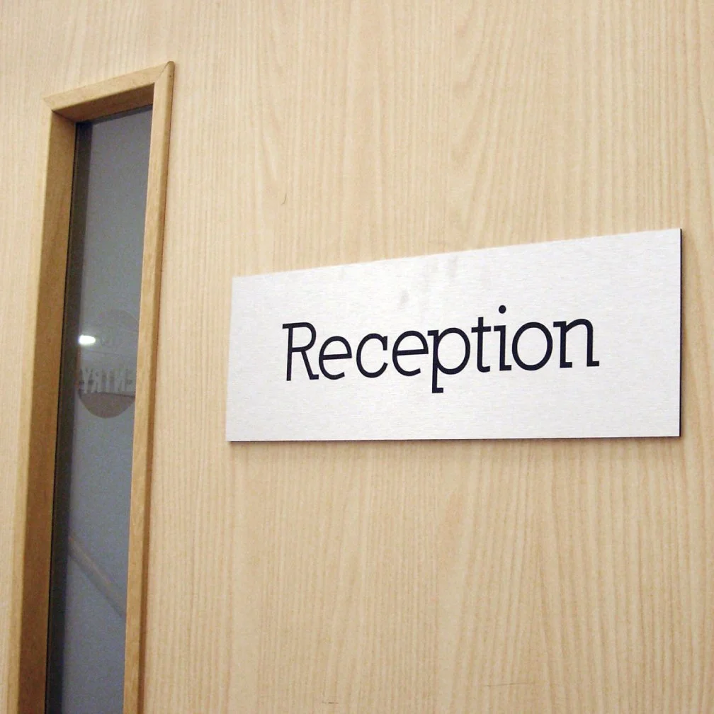 image of brushed aluminum engraved sign on a door in an office.