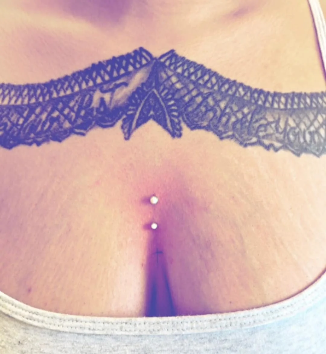 Tattoo and dermal piercings on chest