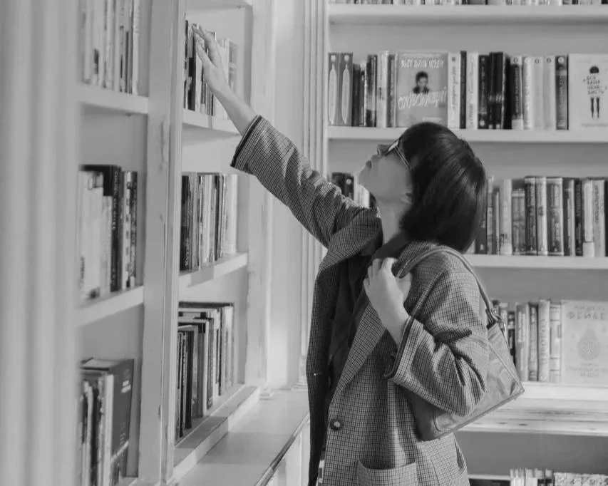 womaninbookshopreachingupforabook