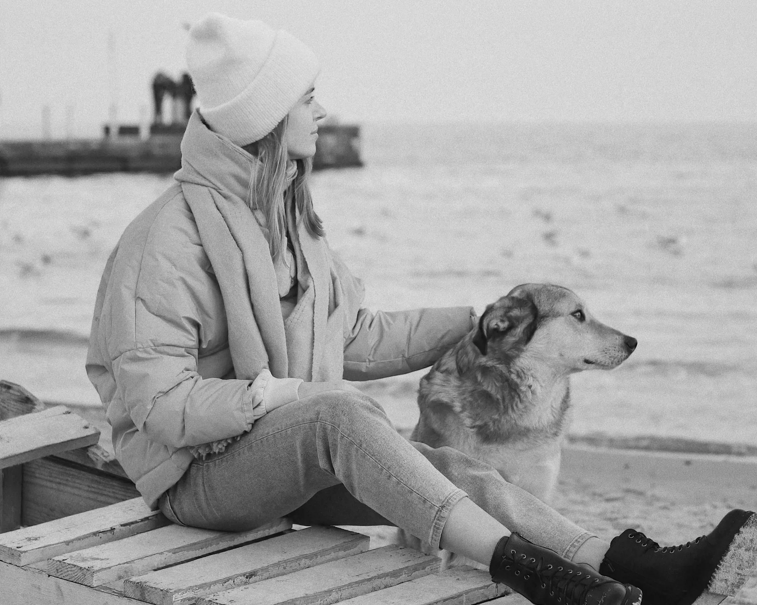 womanlookingat theseawithherdog