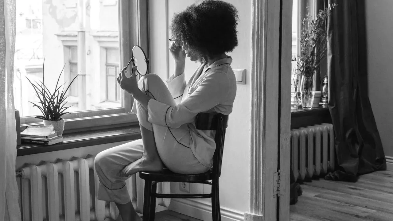 woman applying make up in mirror mariachristie