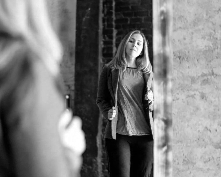 womanlookingatherreflectioninafulllengthmirror