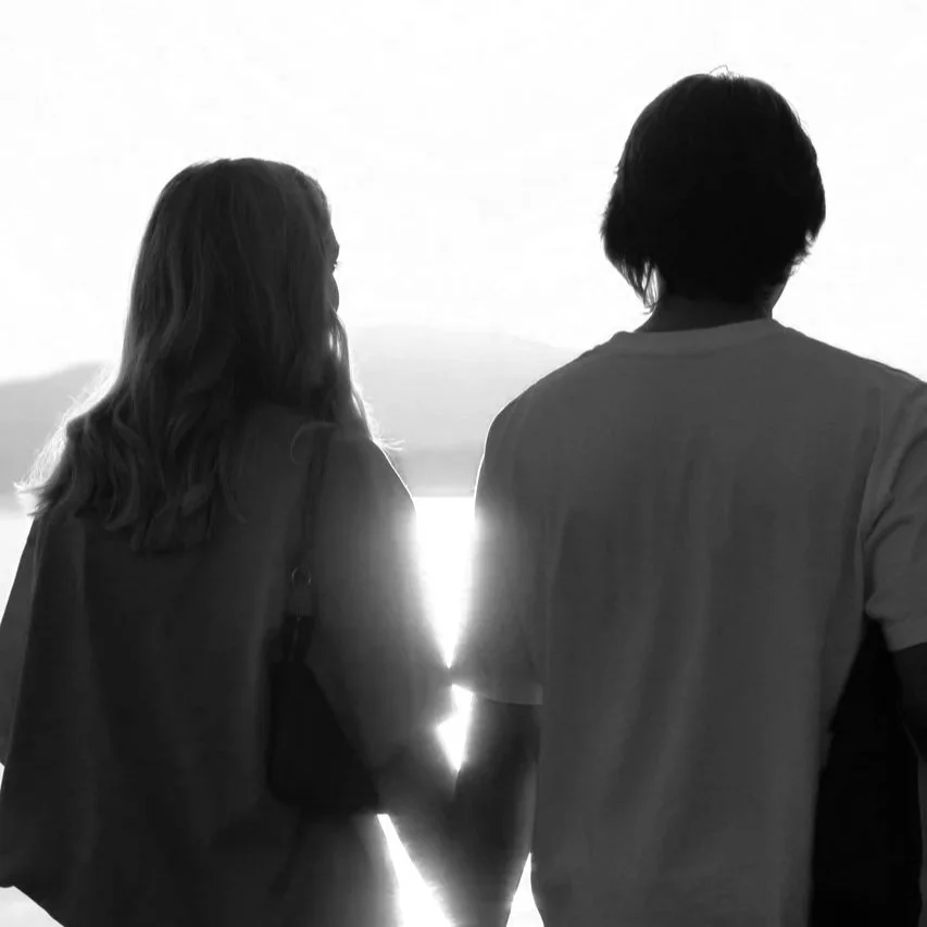 coupleholdinghandswalkingonthe beach