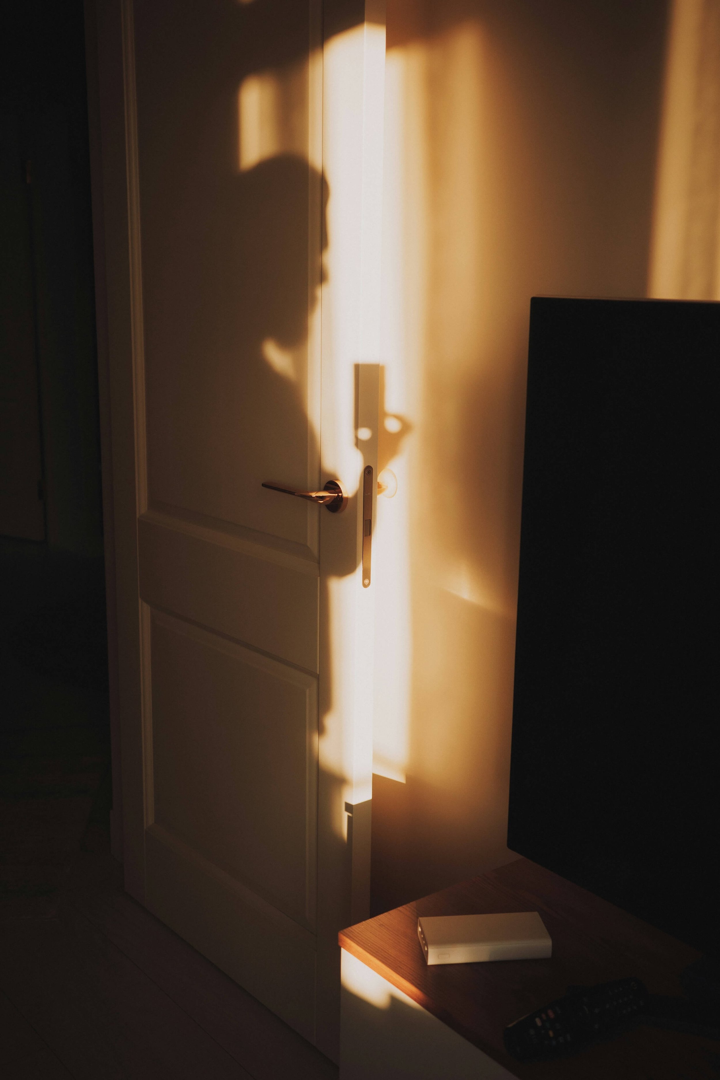 A person's shadow on a white door and wall.