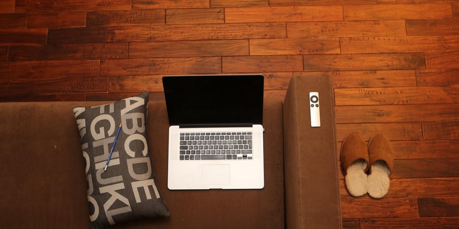 Laptop and cozy home office setup on a couch, representing a calm space to start therapy as a twice exceptional adult