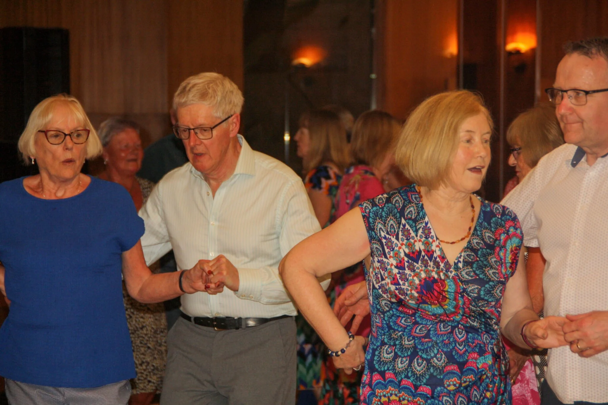 A group of people dancing at a party or social gathering.