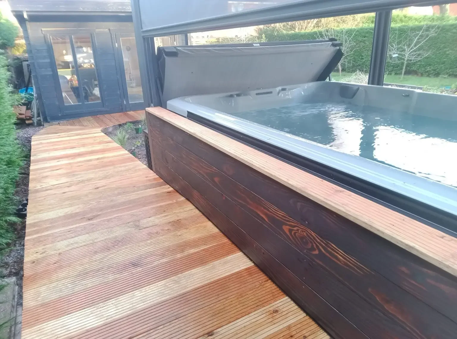 Larch decking installation with bespoke cladding to hot tub / swim spa in Crewe