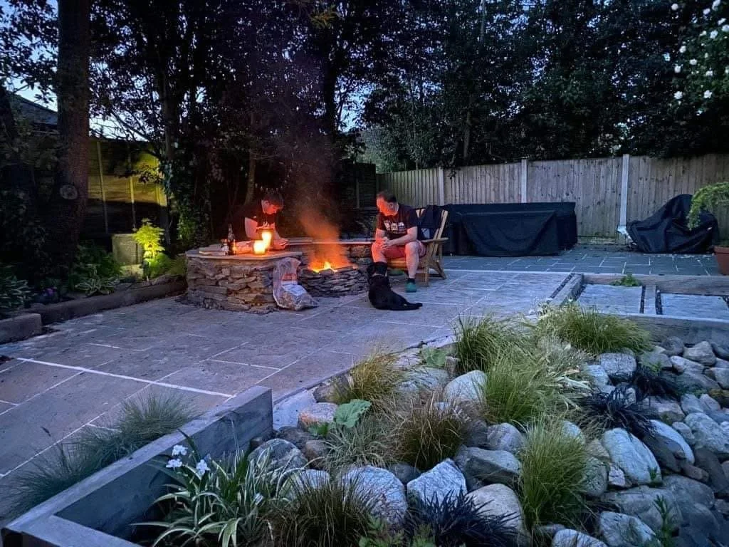 Low maintenance traditional garden design with limestone and slate paving installations plus custom built seating area, fire pit and pond side rockery planting
