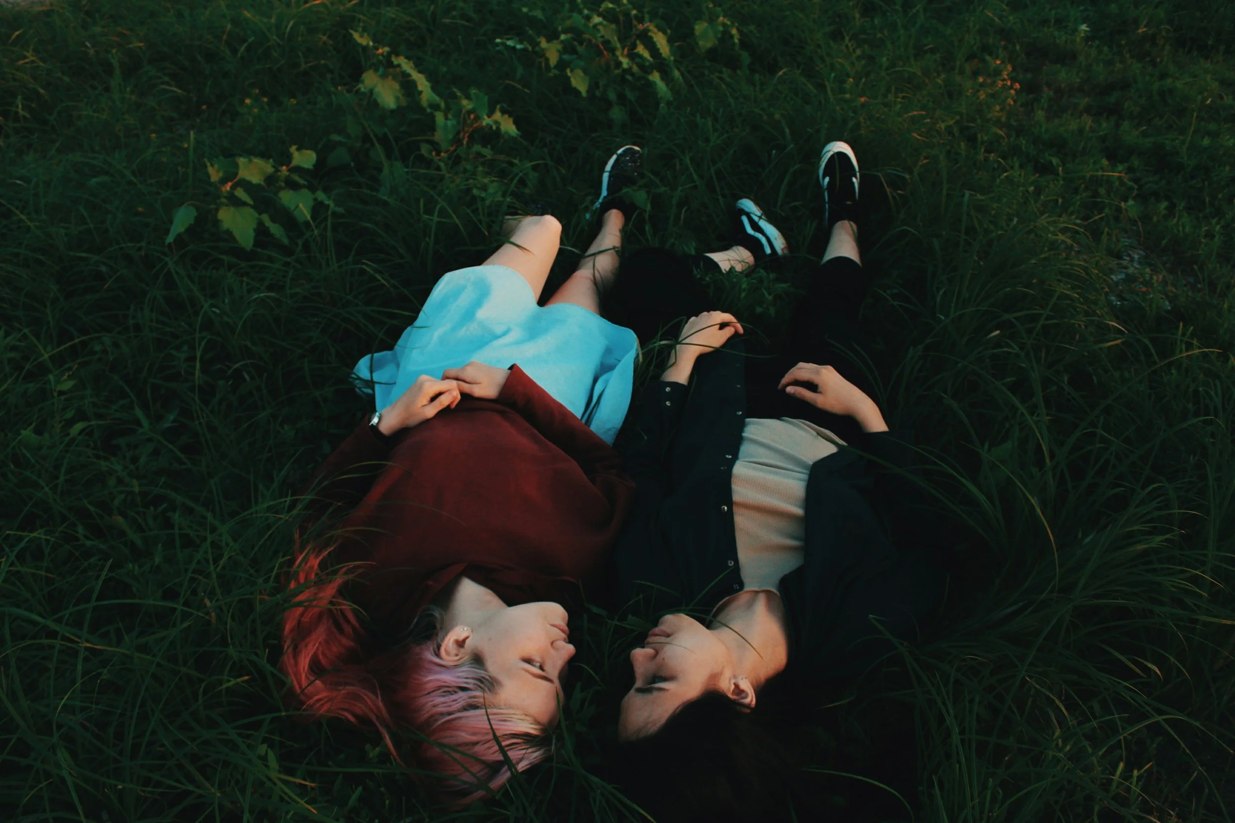 two women laying in the grass