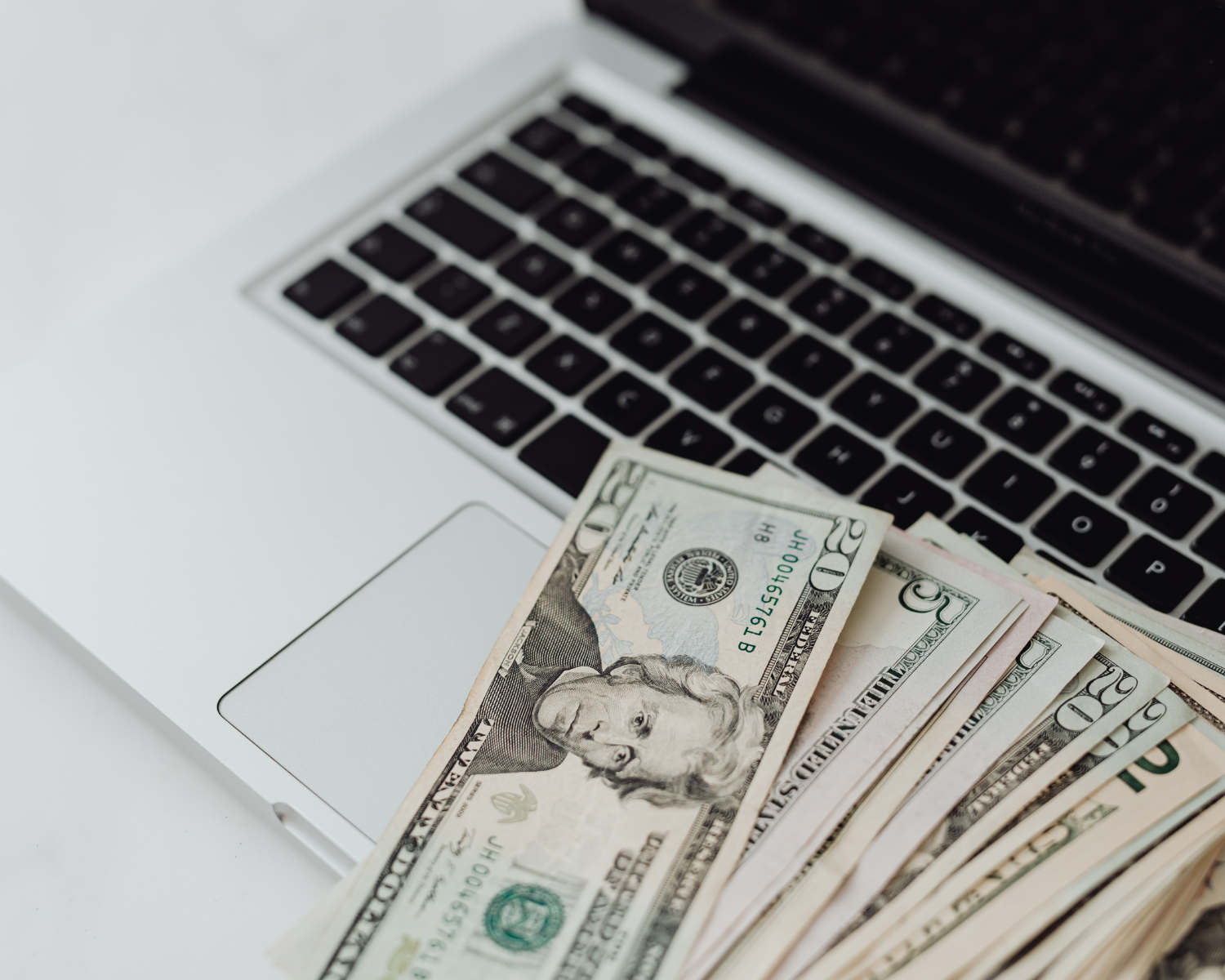 Cash beside a laptop